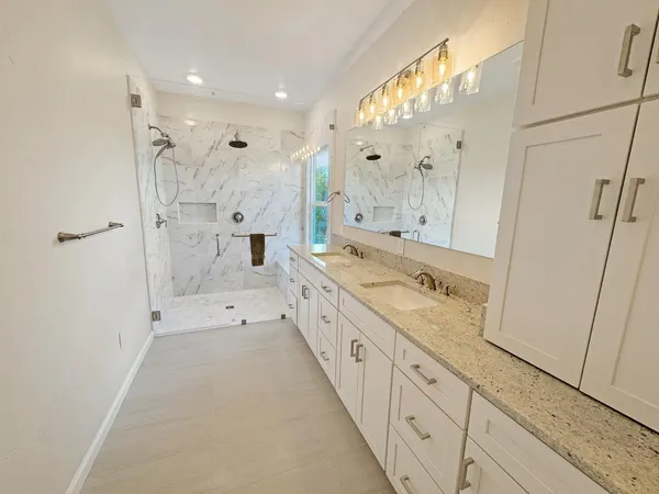 a large bathroom with a granite countertop sink mirror and a shower