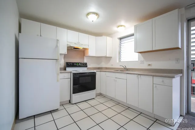 a kitchen with a refrigerator sink and cabinets