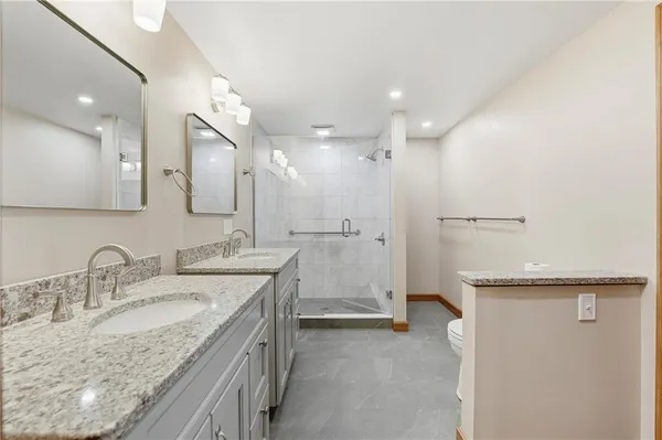 a bathroom with a granite countertop sink mirror and a shower