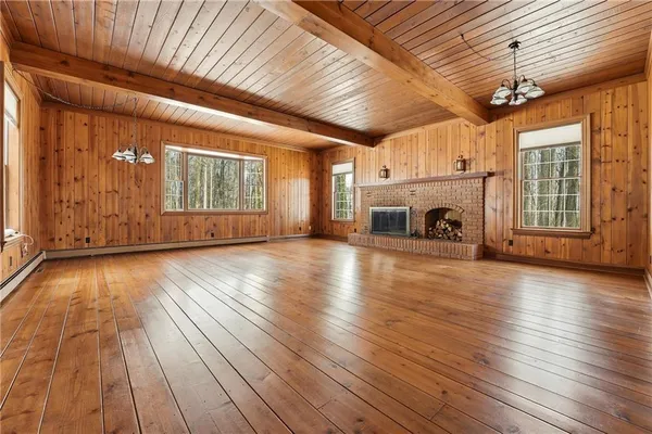 a view of empty room with wooden floor and fireplace