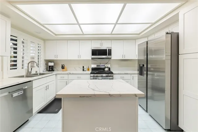 a kitchen with stainless steel appliances a refrigerator sink and microwave