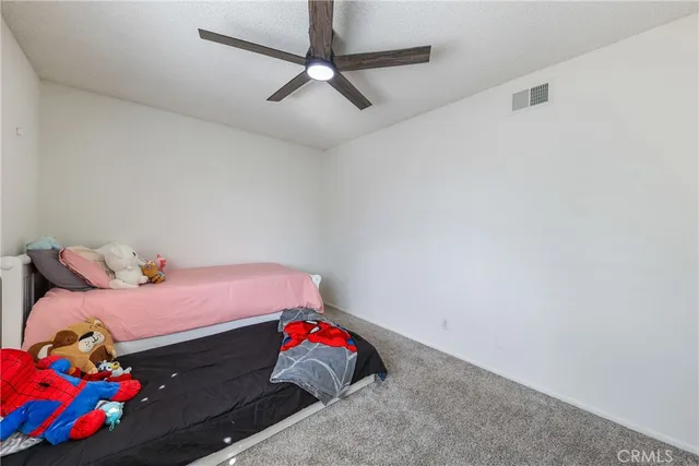 a bedroom with a bed and teddy bear on bed