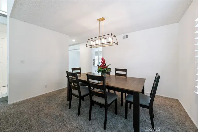 a view of a dining room with a table and chairs
