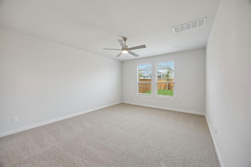 1472 Companero Street Haslet, TX 76052 - Photo 17 of 40 an empty room with windows and ceiling fan