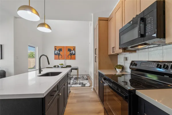 a kitchen with stainless steel appliances granite countertop a stove a sink and a microwave
