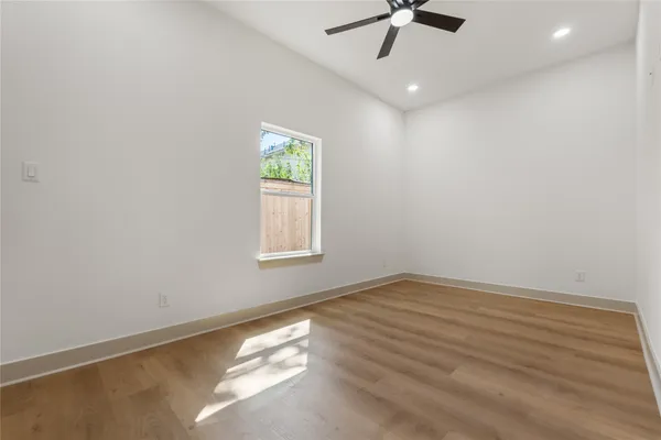 an empty room with a window and a ceiling fan