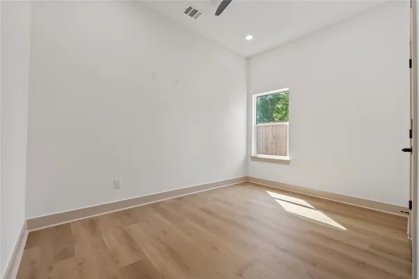 an empty room with wooden floor and window