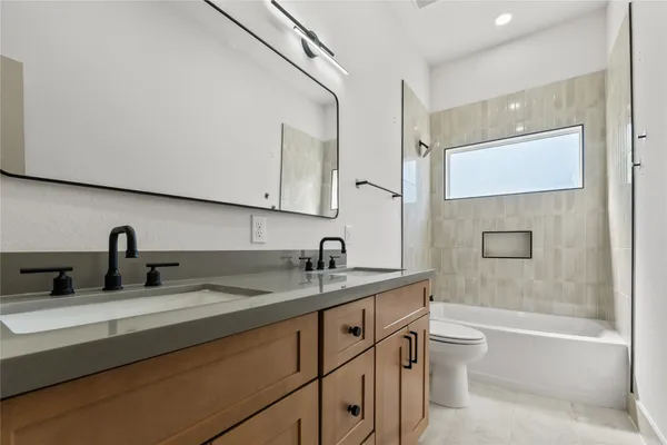a bathroom with a granite countertop sink toilet and mirror