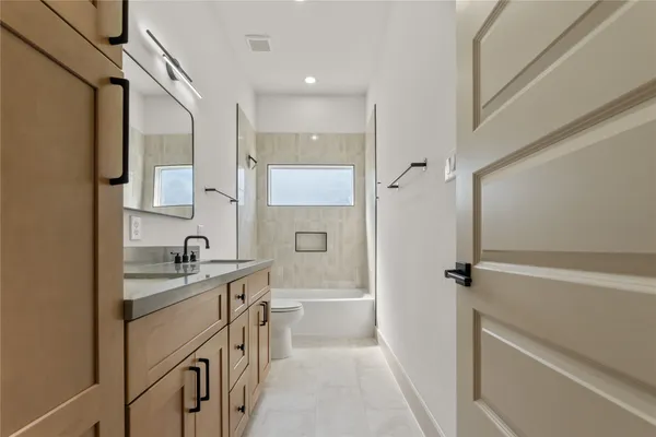a bathroom with a granite countertop sink a toilet and a shower