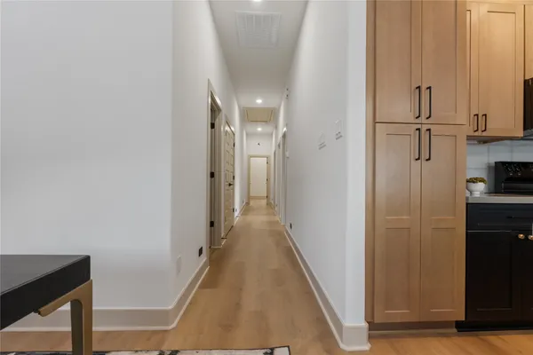 a view of a hallway with wooden floor and staircase