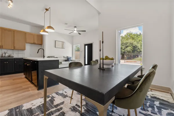 a kitchen with stainless steel appliances granite countertop a sink a stove and chairs