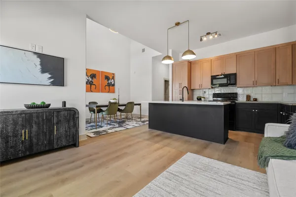 a kitchen with stainless steel appliances kitchen island granite countertop a refrigerator a stove top oven a sink and dishwasher