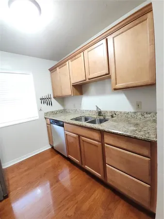 a kitchen with granite countertop wooden cabinets a sink and a window