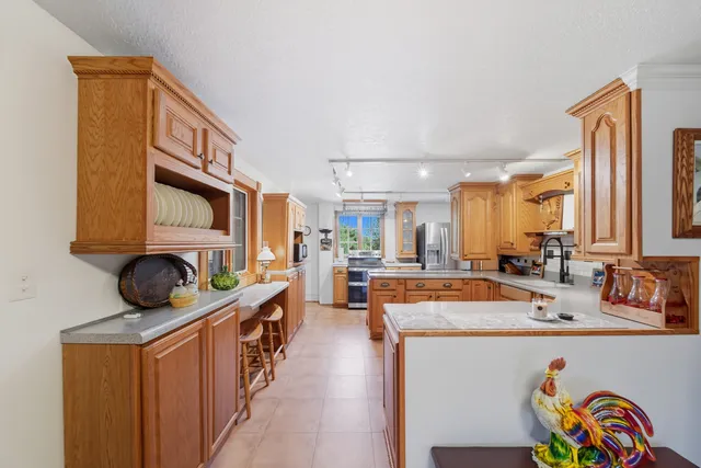 a kitchen with stainless steel appliances granite countertop sink stove and refrigerator