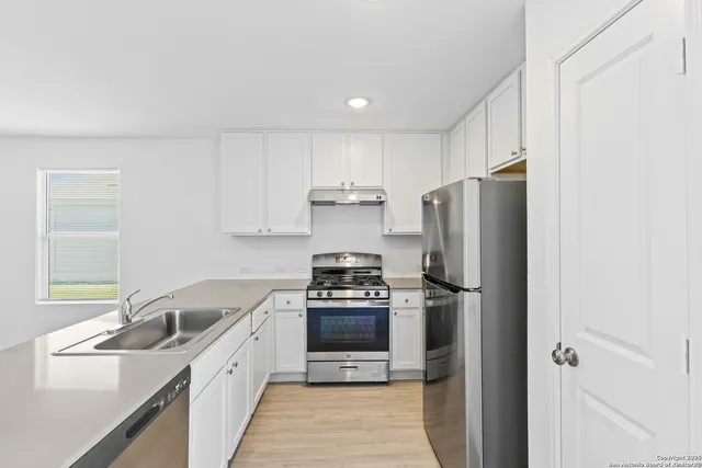 a kitchen with a refrigerator sink and stove