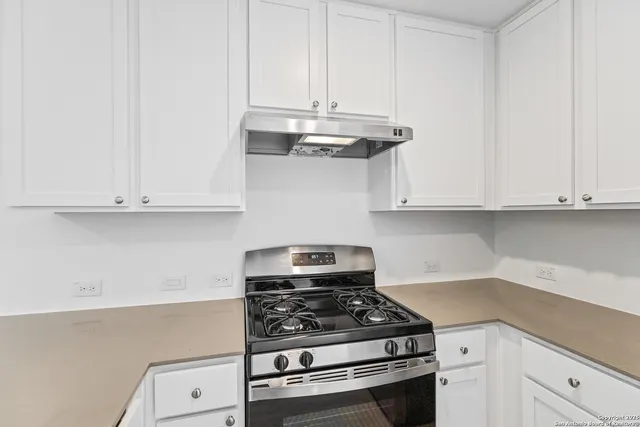 a kitchen with white cabinets and appliances