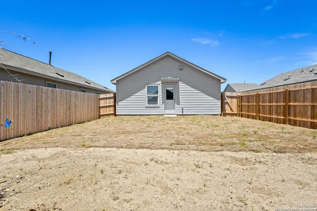 a view of a backyard of a house with wooden fence
