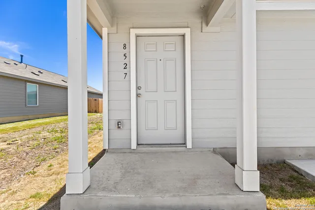 a view of a hallway with wooden floor and a bathroom