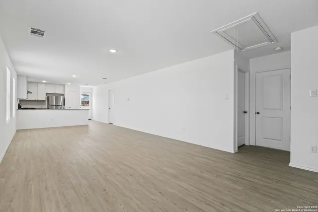 a view of a kitchen with wooden floor and a sink