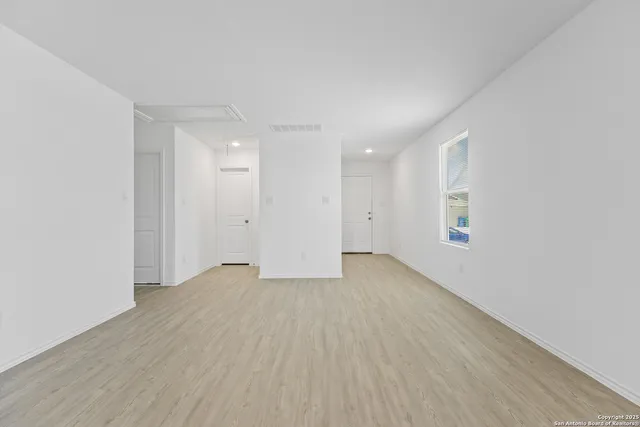 a view of an empty room with wooden floor