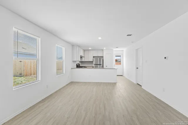a view of a kitchen with wooden floor and windows
