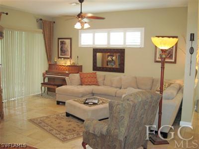 6119 Manchester Place Naples, FL 34110 - Photo 2 of 10 a living room with furniture and a fireplace