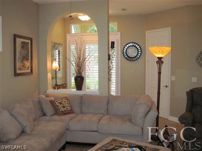 6119 Manchester Place Naples, FL 34110 - Photo 3 of 10 a living room with furniture and a large window