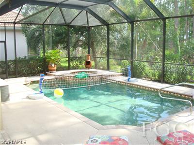 6119 Manchester Place Naples, FL 34110 - Photo 5 of 10 a swimming pool with lawn chairs next to yard