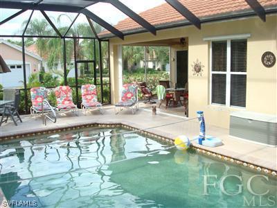 6119 Manchester Place Naples, FL 34110 - Photo 6 of 10 a swimming pool with outdoor seating and yard