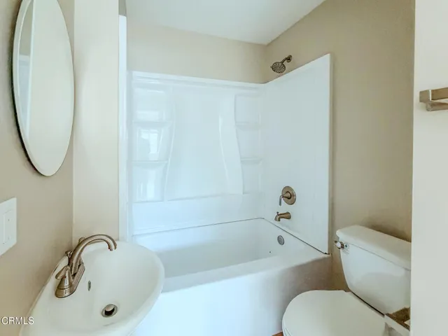 a bathroom with a sink a mirror toilet and bathtub