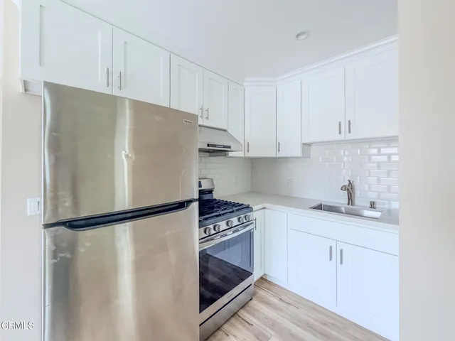 a kitchen with white cabinets and white appliances