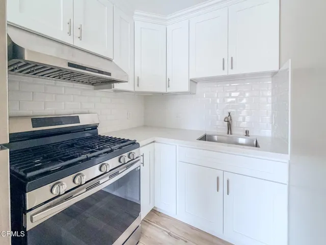 a kitchen with white cabinets and appliances
