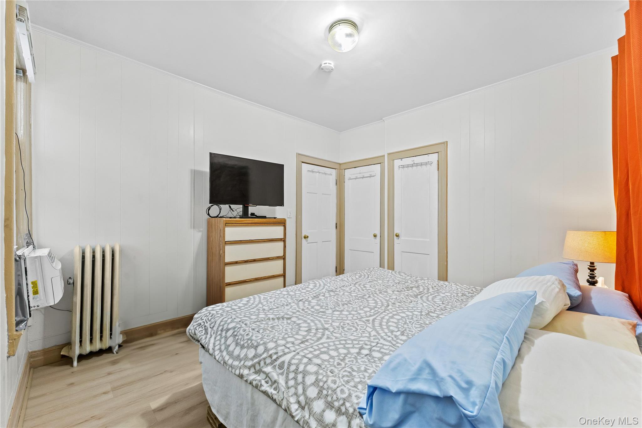 91-49 86th Street Queens, NY 11421 - Photo 13 of 42 a bedroom with a bed and a flat tv screen on a dresser