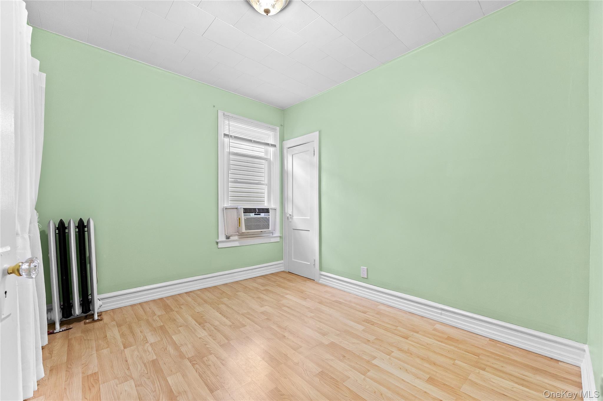 91-49 86th Street Queens, NY 11421 - Photo 23 of 42 an empty room with wooden floor and a window