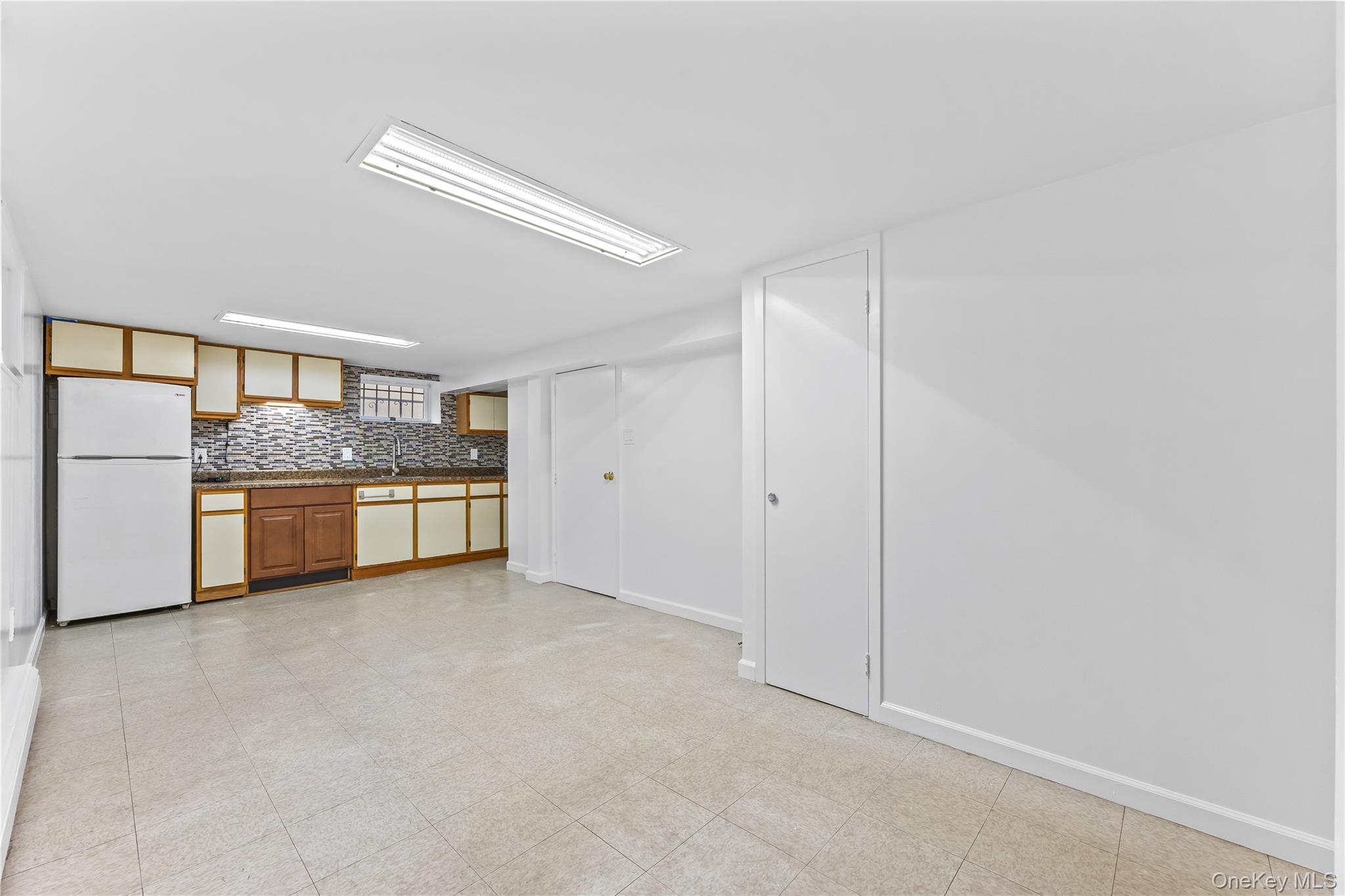 91-49 86th Street Queens, NY 11421 - Photo 31 of 42 a view of a kitchen with a sink and dishwasher a refrigerator with white cabinets