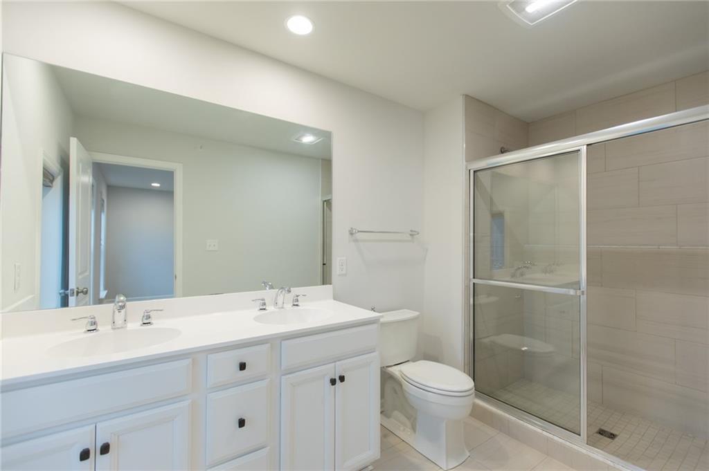 107 Gress Road Cranberry Township, PA 16066 - Photo 13 of 23 The primary bath offers a bright, spa-like retreat with clean lines and thoughtfully selected finishes. A spacious double bowl vanity with crisp white cabinetry and ample storage provides both style and everyday convenience, making morning routines effortless. The expansive mirror and modern lighting enhance the open feel while keeping the space light and functional.