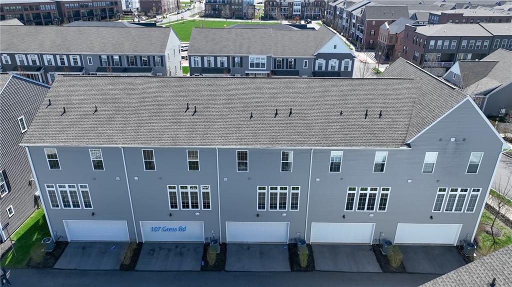 107 Gress Road Cranberry Township, PA 16066 - Photo 3 of 23 The rear exterior of the townhome is both polished and highly functional, showcasing a private two-car garage with a wide driveway for easy access and ample parking.