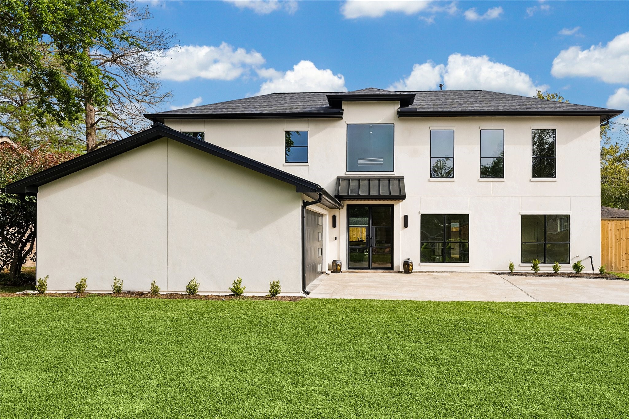 5430 Rutherglenn Drive Houston, TX 77096 - Photo 30 of 31 This modern two-story home features a sleek white exterior with black trim and large windows. It includes a spacious driveway, manicured lawn, and a welcoming front entrance. Ideal for contemporary living and ready for you!