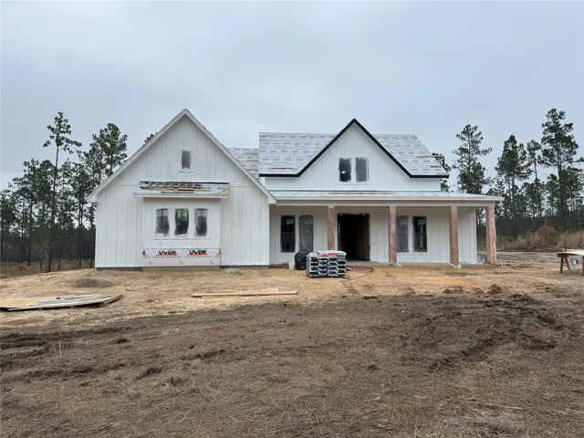a front view of a house with a garden and trees