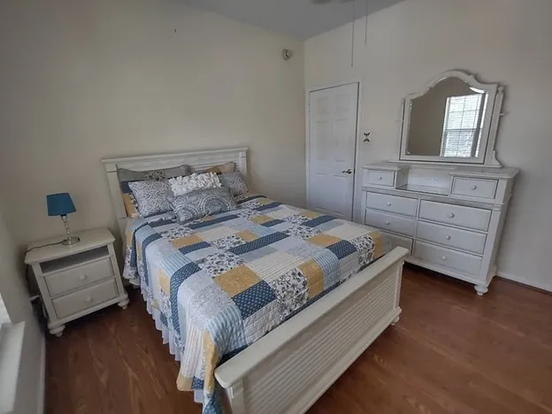 a spacious bedroom with a bed and a dresser