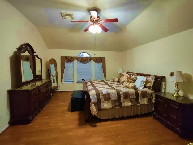 a bedroom with bed and wooden floor