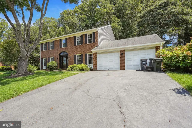 a view of an empty room with wooden floor and a fireplace