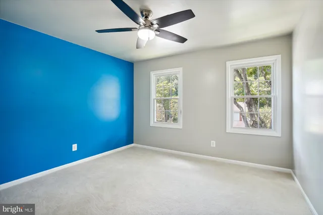 a view of an empty room with wooden floor fireplace and a window