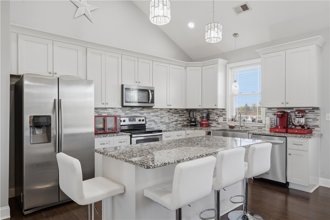 1312 Falcons Drive Walhalla, SC 29691 - Photo 9 of 34 This modern kitchen features a spacious island, white cabinetry, and stainless steel appliances.