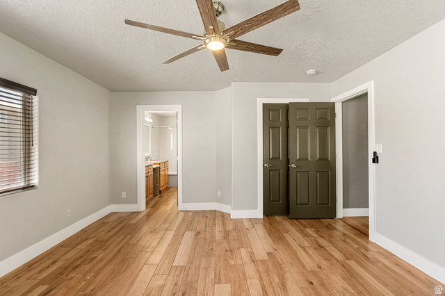 55 Spring Drive Toquerville, UT 84774 - Photo 24 of 36 Unfurnished bedroom featuring light wood-type flooring, a textured ceiling, a ceiling fan, and connected bathroom
