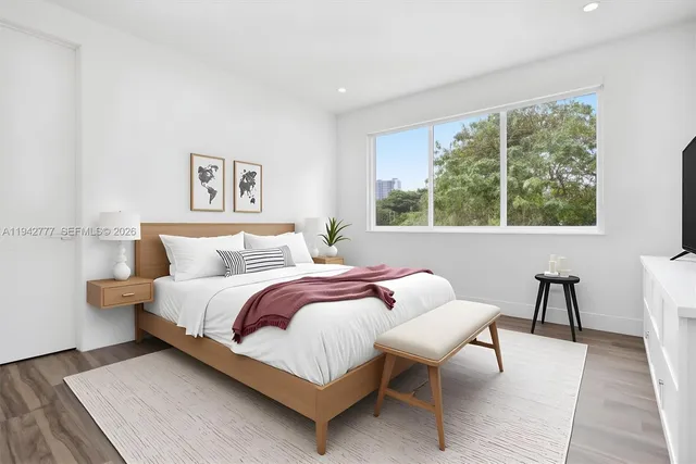 a bedroom with furniture and a large window