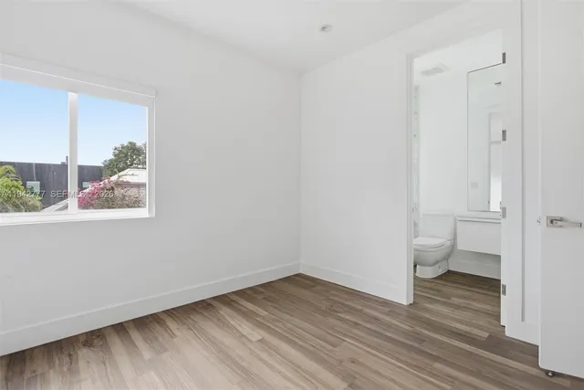 a view of a room with wooden floor and window