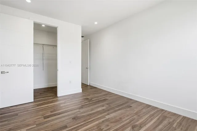 an empty room with wooden floor & closet