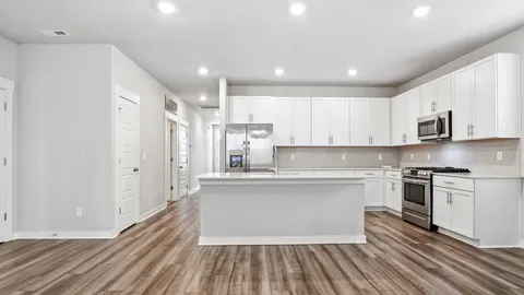 a kitchen with stainless steel appliances granite countertop a stove top oven a sink and a refrigerator