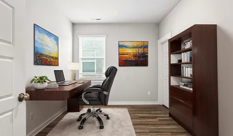 a view of a workspace with furniture and wooden floor